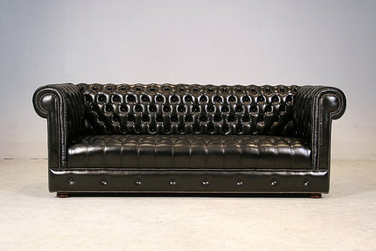 Chesterfield 3-Seater Sofa in black genuine leather — front hero view showing full diamond button tufting on back, seat and apron with nail head trim