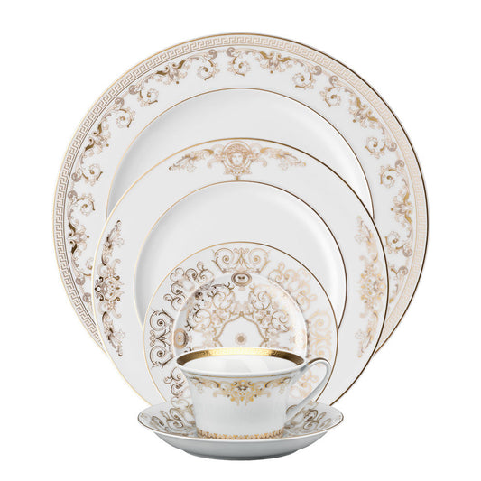 A 5-piece Versace Medusa Gala porcelain dinnerware set, including a cup and plates with gold decorations, displayed against a white background.