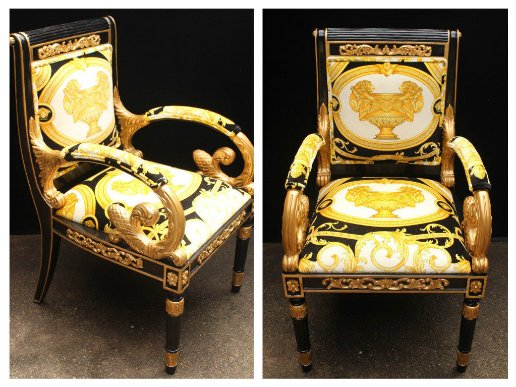A pair of luxury custom Vanitas armchairs covered in Versace Gold Double Lion Petit-Petitot fabric, with black and gold color scheme and ornate designs.
